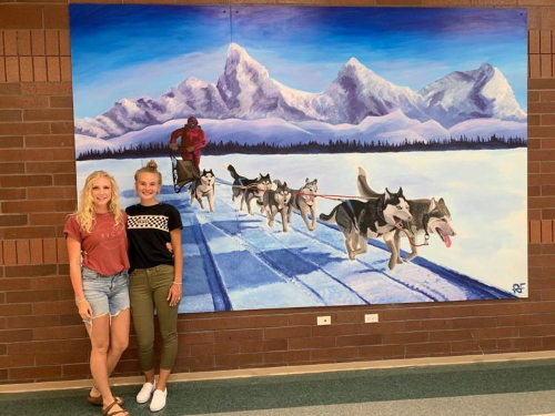 2019 North Fremont High School grads Alexa Nedrow and Renee Fabanich recently put the finishing touches on the American Dog Derby mural they created at the high school. The mural is in homage to the annual derby that’s been held in Ashton since 1917.