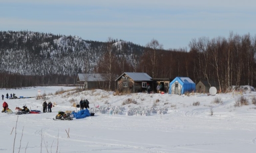 The austere iditarod checkpoint, with just two major shelter structures, and tents or converted out buildings set up for Iditarod. (Photo by Zachariah Hughes/ Alaska Public Media)