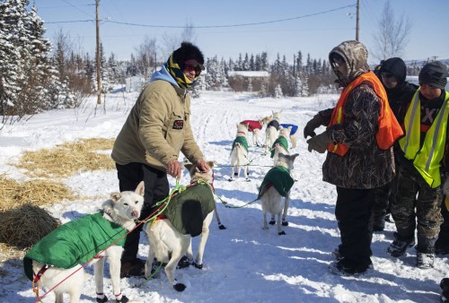 Musher Hugh Neff talks with Kobuk 440 volunteer Martin Cleveland before he leaves Ambler en route to Kobuk as he competes in the Kobuk 440 sled dog race on Friday, April 8, 2022. (Emily Mesner / ADN)
