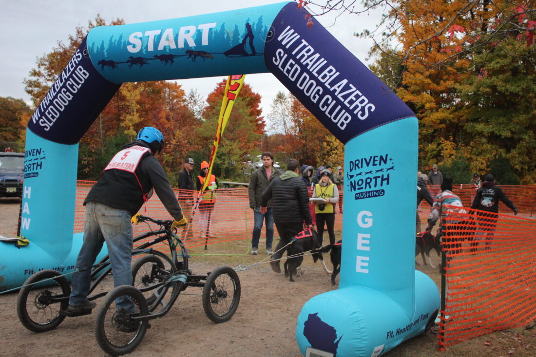 Unnamed Musher riding through the Starting gate | Image/Article: Antonio Anderson, The Mining Journal